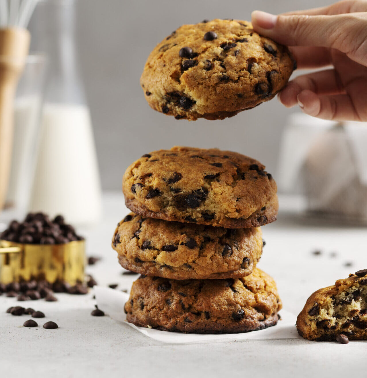 side-view-hand-holding-chocolate-chips-cookie